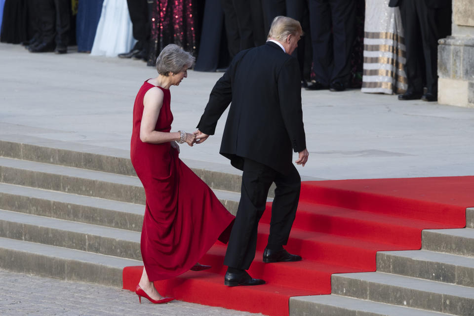 <p>British Prime Minister Theresa May takes the hand of President Donald Trump as they walk up red-carpeted steps to enter Blenheim Palace for a black tie dinner in Blenheim, England, Thursday, July 12, 2018. (Photo: Will Oliver/Photo via AP) </p>