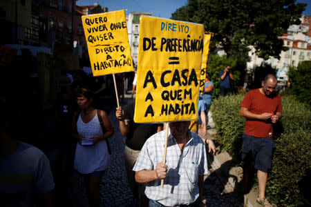 A man holds a sign reading "House to who lives in it" during a demonstration against evictions and rising rent prices in central Lisbon, Portugal September 22, 2018. REUTERS/Pedro Nunes