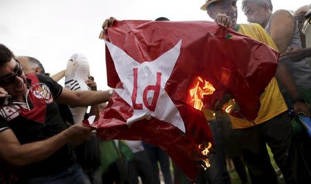 Demonstrators burn a Worker Party flag during a protest calling for the impeachment of Brazil's President Dilma Rousseff in front of the National Congress in Brasilia, Brazil, December 13, 2015. REUTERS/Ueslei Marcelino