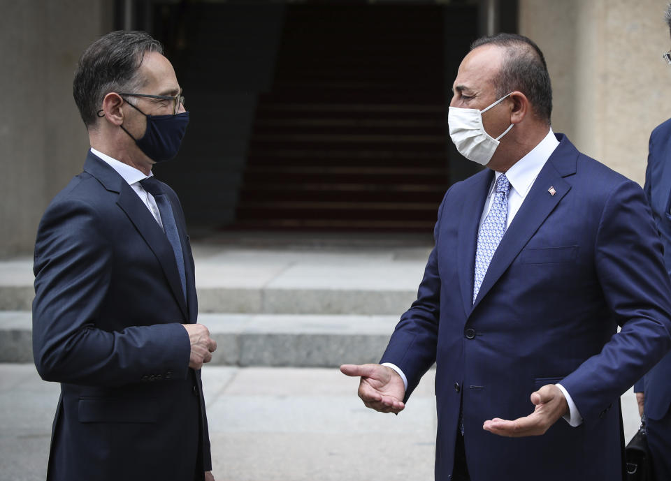 FILE - In this Thursday, July 2, 2020 file photo, Turkey's Foreign Minister Mevlut Cavusoglu, right, and Germany''s Foreign Minister Heiko Maas, wearing face masks to protect against the spread of coronavirus, speak after a meeting in Berlin. A festering row between France and Turkey over a naval standoff in the Mediterranean Sea has shone a glaring searchlight on NATO's struggle to keep order among its ranks and exposed weaknesses in a military alliance that can only take action by consensus. (Cem Ozdel/Turkish Foreign Ministry via AP, Pool, File)