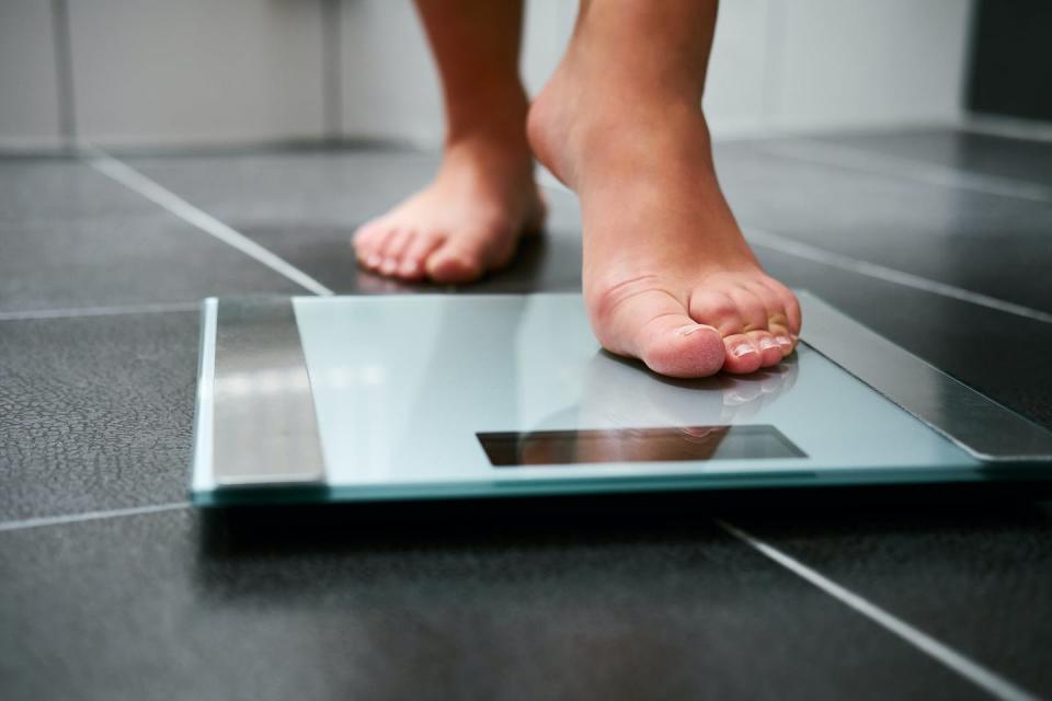 Person steps onto bathroom scales.