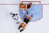 Vancouver Canucks' Alex Chiasson tries to get a shot past Philadelphia Flyers' Carter Hart (79) and Travis Sanheim (6) during the third period of an NHL hockey game, Friday, Oct. 15, 2021, in Philadelphia. (AP Photo/Matt Slocum)