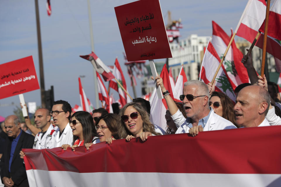 Anti-government doctors shout slogans during separate civil parade at the Martyr square, in downtown Beirut, Lebanon, Friday, Nov. 22, 2019. Protesters gathered for alternative independence celebrations, converging by early afternoon on Martyrs’ Square in central Beirut, which used to be the traditional location of the official parade. Protesters have occupied the area, closing it off to traffic since mid-October. (AP Photo/Hassan Ammar)