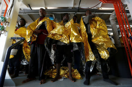 Migrants stand on the deck of Malta-based NGO Migrant Offshore Aid Station (MOAS) ship Phoenix after being rescued from a rubber dinghy in central Mediterranean on international waters some 15 nautical miles off the coast of Zawiya in Libya, April 14, 2017. REUTERS/Darrin Zammit Lupi