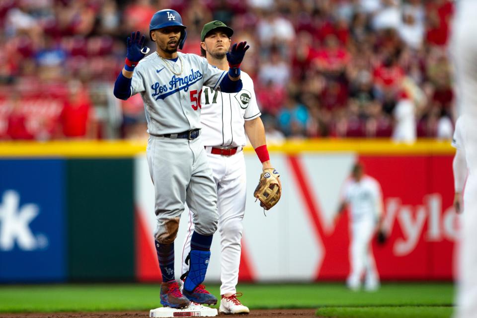 Los Angeles Dodgers right fielder Mookie Betts (50) celebrates as Cincinnati Reds shortstop Kyle Farmer (17) looks on after hitting a double in the first inning of the MLB baseball game between Cincinnati Reds and Los Angeles Dodgers on Friday, Sept. 17, 2021, at Great American Ball Park in Cincinnati. 