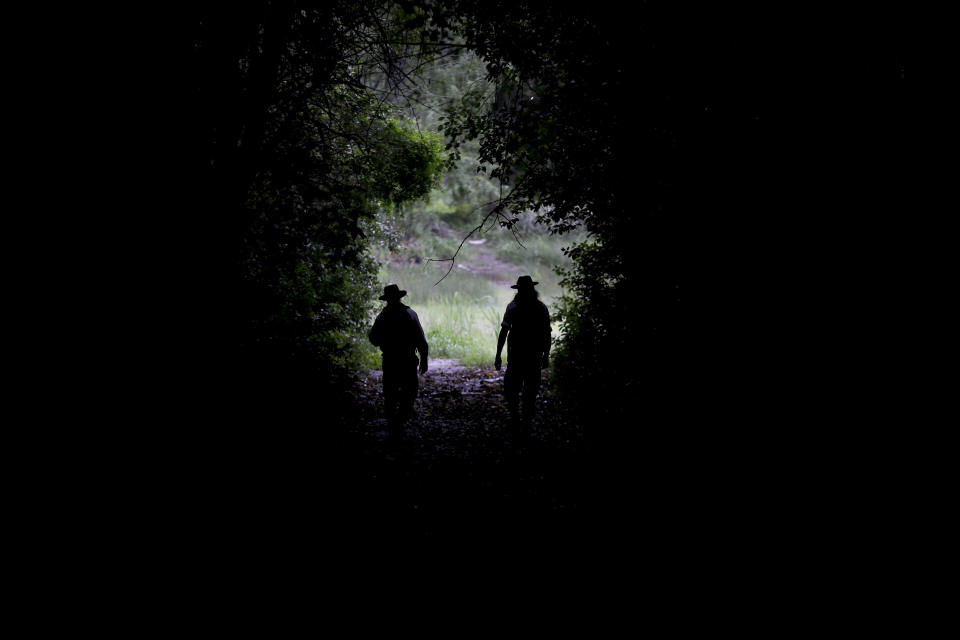 In this Oct. 18, 2018 photo, park rangers Agustin Mezzabotta, right, and Gonzalo Alves walk at "Ciervo de los Pantanos" National Park near Buenos Aires, Argentina. The until-now little-known area, home to a wide range of birds, fish and other wildlife, has become Argentina's newest national park in a victory for nature preservation at a time when the country is facing an economic crisis and governments worldwide are cutting back funding for parks and environmental programs. (AP Photo/Natacha Pisarenko)