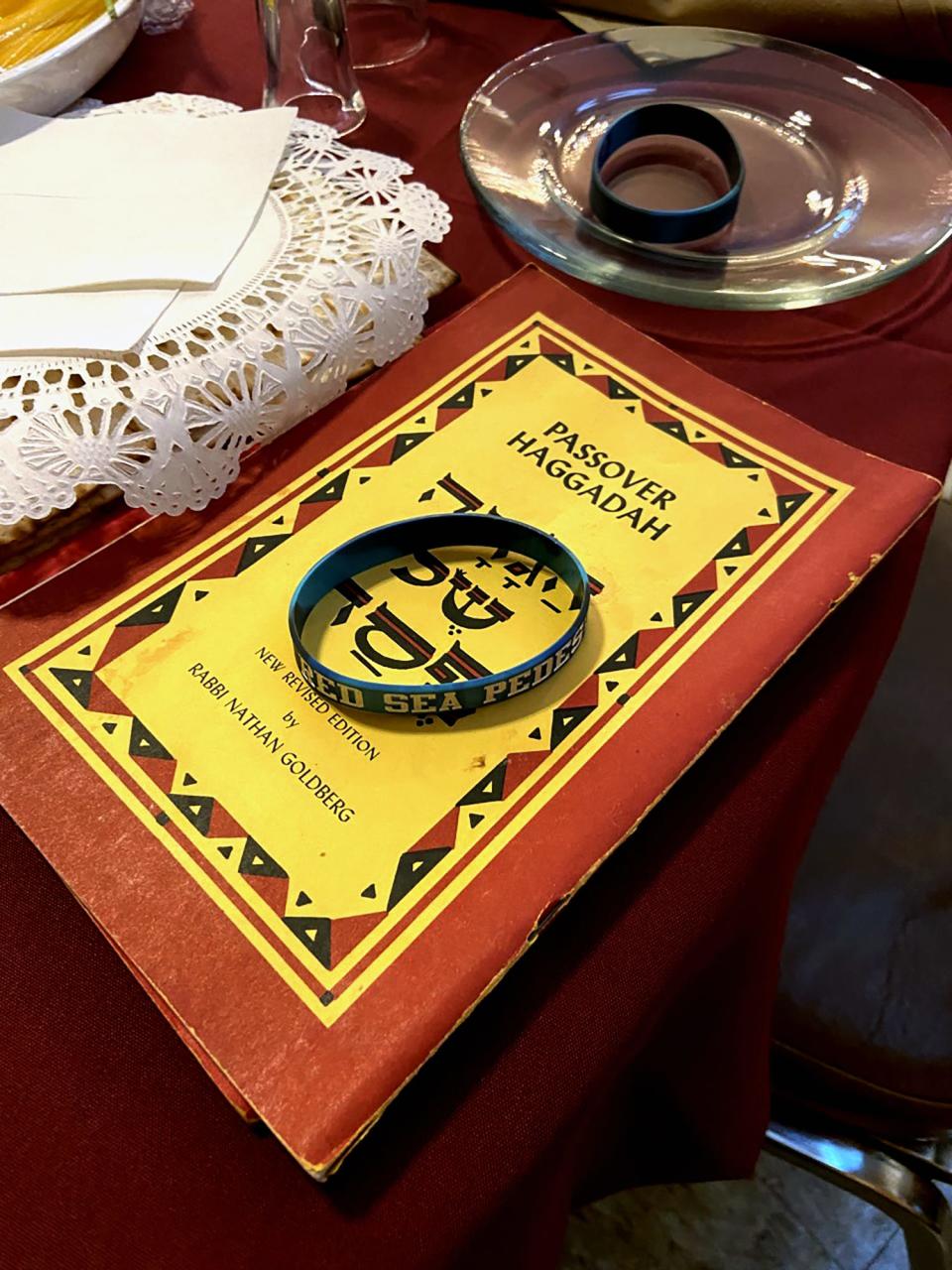 Guests wore "Red Sea Pedestrian" wrist brands, shown here with a Haggadah, at a Passover Seder at Emanuel Synagogue.