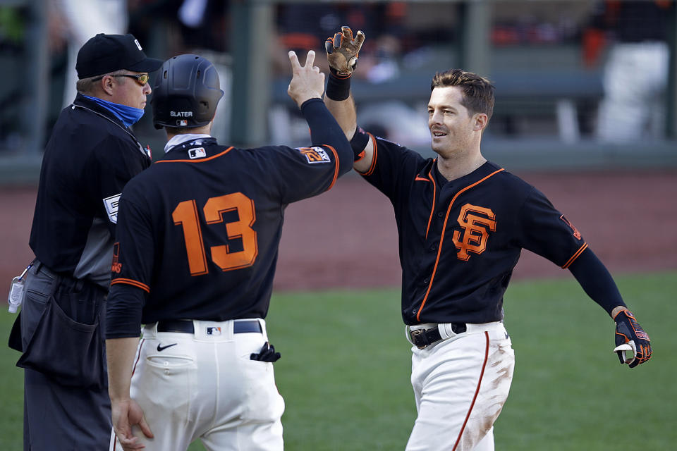 San Francisco Giants' Mike Yastrzemski, right, celebrates with Austin Slater (13) after the two scored during the fourth inning of a baseball game against the Oakland Athletics on Saturday, Aug. 15, 2020, in San Francisco. Yastrzemski tripled, and scored on a throwing error by Athletics' Marcus Semien. (AP Photo/Ben Margot)