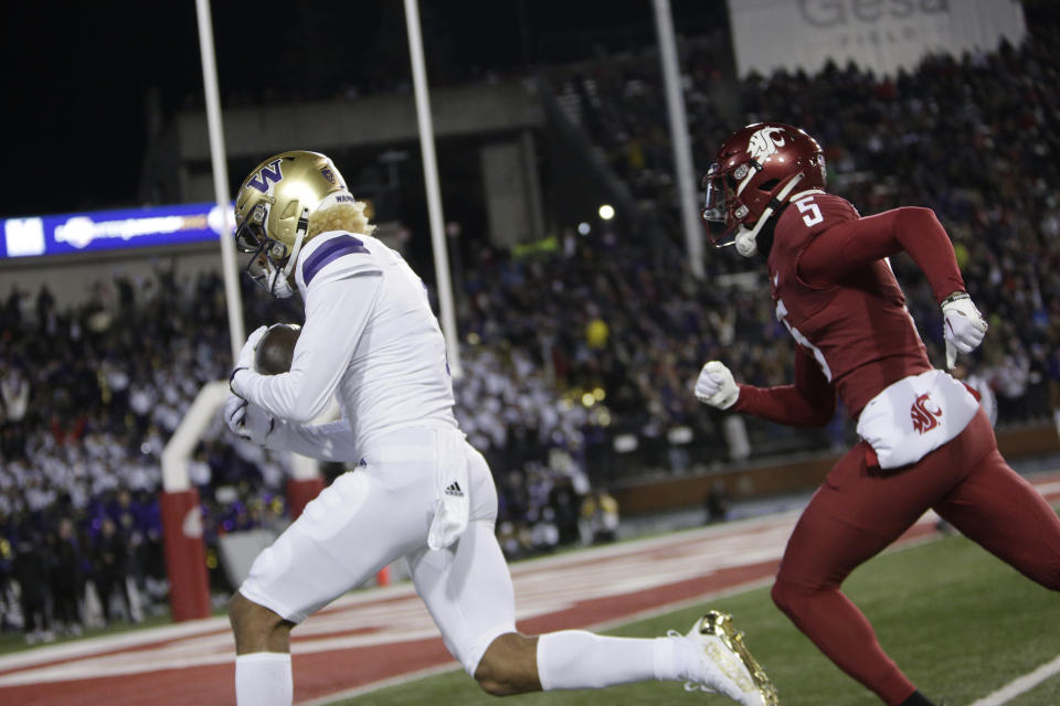 Washington wide receiver Rome Odunze, left, runs for a touchdown while defended by Washington State defensive back Derrick Langford Jr. during the first half of an NCAA college football game, Saturday, Nov. 26, 2022, in Pullman, Wash. (AP Photo/Young Kwak)