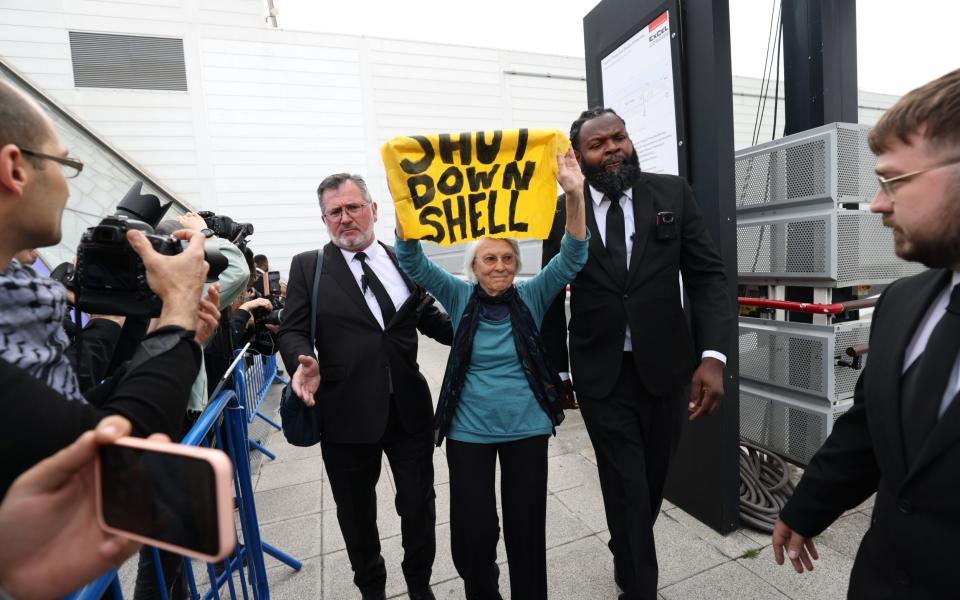 A Shell protester is led out of the AGM - Belinda Jiao