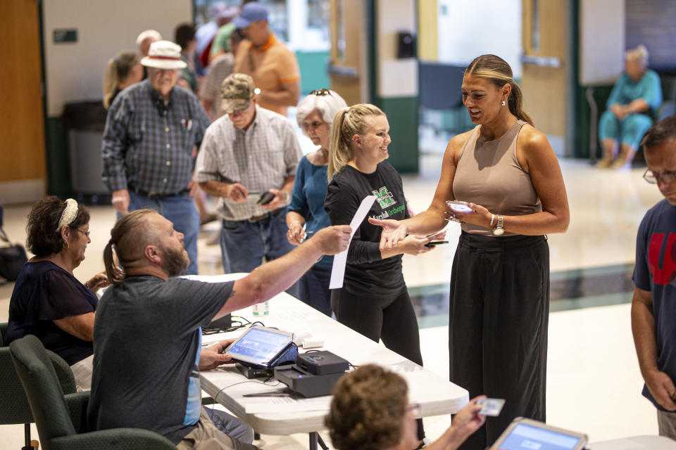 Voters receive their ballots as Lawrence County residents head to the polls to vote on Ohio Issue 1 during a special one-issue election Tuesday, Aug. 8, 2023, at Fairland High School in Proctorville, Ohio. (Sholten Singer/The Herald-Dispatch via AP)