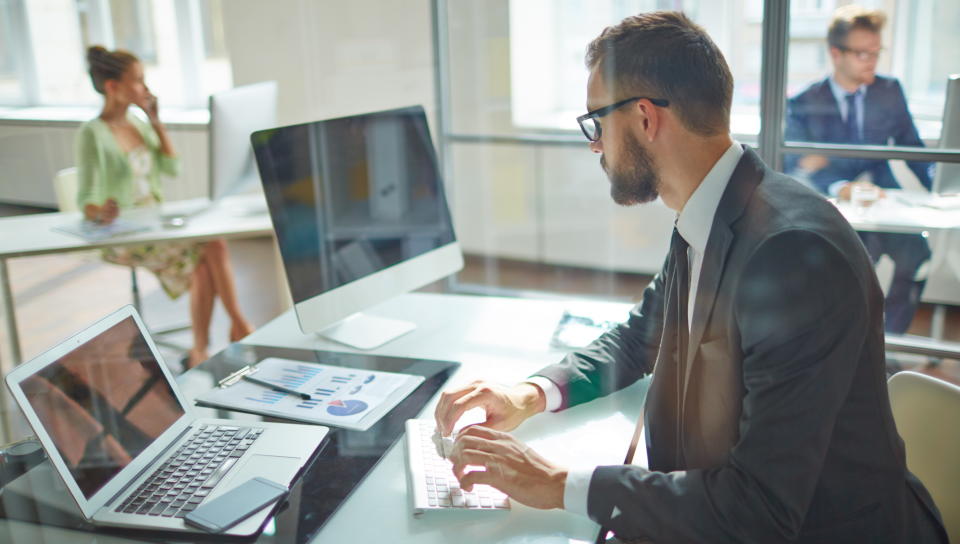 man sat at desk working on computer