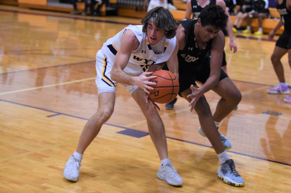 Wylie's Harrison Heighton (55) holds onto an offensive rebound during Tuesday's game against Lubbock High.