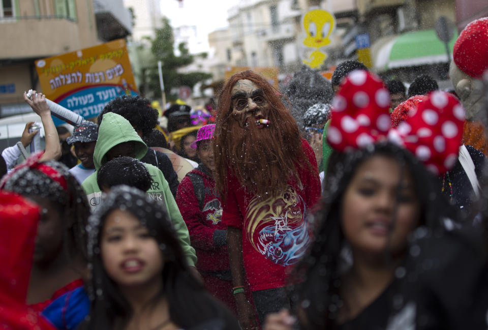 Young children of foreign migrant workers, wear masks as they march during a Purim parade in Tel Aviv, Israel, Friday, Feb. 22, 2013. (AP Photo/Ariel Schalit)