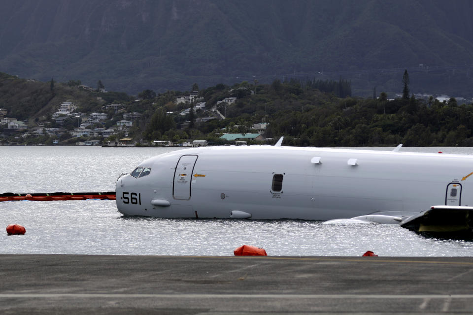 FILE - A Navy P-8A plane that overshot a runway at Marine Corps Base Hawaii and landed in shallow water offshore sits on a reef and sand in Kaneohe Bay, Hawaii, on Monday, Nov. 27, 2023. The U.S. Navy says underwater footage shows two points where the large plane is touching coral in a Hawaii bay. (AP Photo/Audrey McAvoy,File)