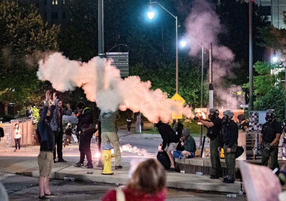 Fireworks explode as police shoot tear gas and rubber bullets at protestors during a second night of protesting in downtown Asheville in response to the killing of George Floyd, who is black, by a white police officer in Minneapolis on June 1, 2020. 