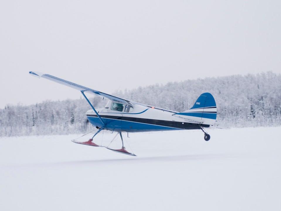 Bush plane taking off from a frozen lake in Alaska.