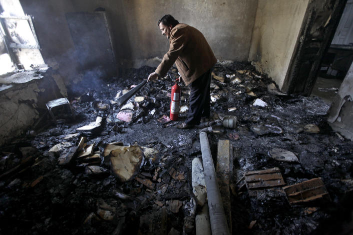 FILE - In this March 21, 2011, file photo, a man uses a fire extinguisher in a burned out courtroom that was set on fire by anti-government protesters in the southern city of Daraa, Syria. In March 2011, Daraa became the first city to explode against the rule of Syrian President Bashar Assad. (AP Photo/Hussein Malla, File)