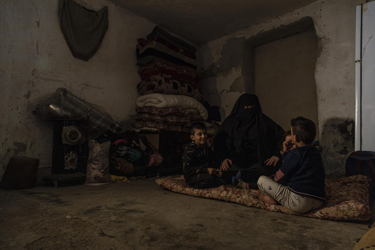 Marwa Ahmadsits with her children in Raqqa, Syria, Wednesday, Dec. 28, 2022. Ahmad is among tens of thousands of widows and wives of IS militants who were detained in the wretched and lawless al-Hol camp in northeastern Syria after U.S.-led coalition and Syrian Kurdish forces cleared IS from northeastern Syria in 2019. (AP Photo/Baderkhan Ahmad)