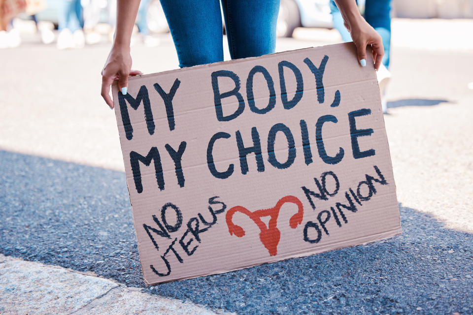 Mujer protesta sobre el aborto y tiene un letrero que dice 