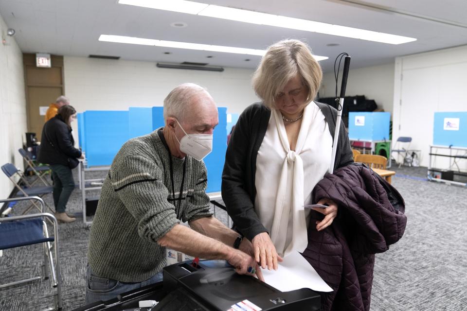 Patti Chang, who is blind, receives help from poll worker Bruce Mocking to vote in the Chicago mayoral runoff election at the Roden Branch of the Chicago Public Library Wednesday, March 22, 2023, in Chicago. (AP Photo Erin Hooley)