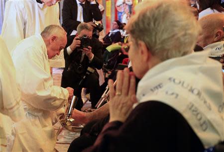 Pope Francis washes a foot of a disabled person at the S. Maria della Provvidenza church in Rome, during the Holy Thursday celebration, April 17, 2014. REUTERS/Tony Gentile