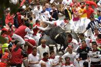 <p>Revellers run as others fall on Miura’s fighting bulls during the running of the bulls at the San Fermin Festival, in Pamplona, northern Spain, July 14, 2017. (Photo: Alvaro Barrientos/AP) </p>