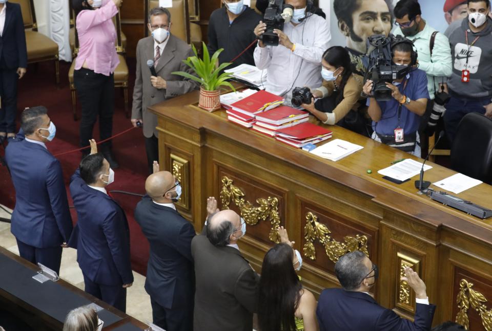 Venezuela's new National Electoral Council directors are sworn in during an extraordinary session at the National Assembly in Caracas, Venezuela, Tuesday, May 4, 2021. The National Assembly, with an overwhelming pro-government majority, on Tuesday appointed two recognized opponents as members of the new board of the National Electoral Council of Venezuela. (AP Photo/Ariana Cubillos)