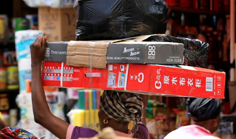 A woman carries goods on her head at Balogun market in Nigeria's commercial capital Lagos