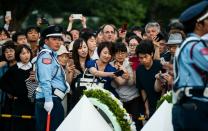 Crowds try to get a glimpse of the wreath laid by US President Obama at the Hiroshima Peace Memorial Park cenotaph on May 27, 2016