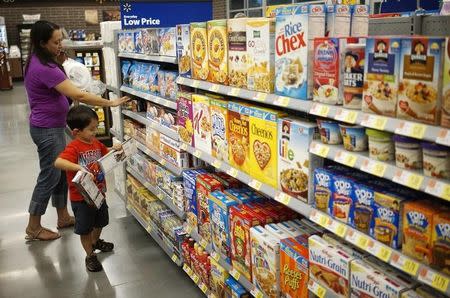 Una mujer y un niño comprando en una tienda Walmart to Go, en Bentonville, Arkansas, Estados Unidos. 5 de junio de 2014. El gasto del consumidor en Estados Unidos registró su mayor alza en más de seis años en abril debido a que los hogares incrementaron las compras de automóviles, lo que sugiere una aceleración del crecimiento económico que podría persuadir a la Reserva Federal a elevar las tasas de interés pronto. REUTERS/Rick Wilking