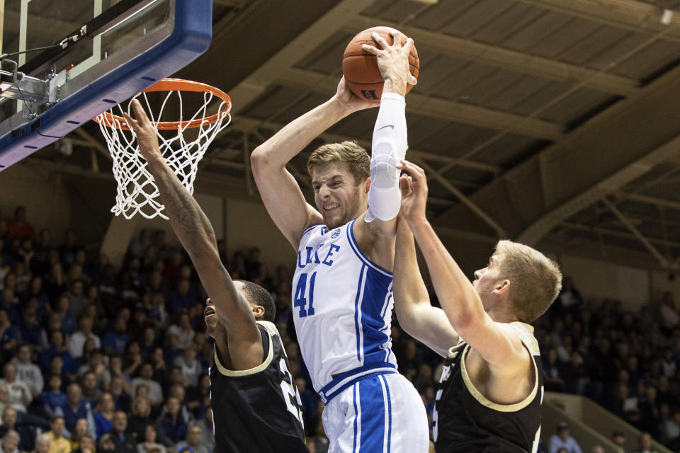 Duke's Jack White (41) grabs a rebound between Wofford's Messiah Jones, left, and Trevor Stumpe, right, during the first half of an NCAA college basketball game in Durham, N.C., Thursday, Dec. 19, 2019. (AP Photo/Ben McKeown)