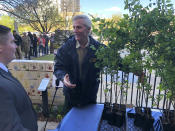 Mark Bays, right, a forester with Oklahoma Forestry Services, greets a man who waited in line to get an American elm sapling Friday, April 19, 2019. In Oklahoma City. The tree grew out of a seed from the "Survivor Tree" that is a symbol of hope after the deadly 1995 Oklahoma City bombing. Science and technology are helping Oklahoma City to sustain the DNA of a tree symbolizing hope 24 years after the deadliest act of domestic terrorism on U.S. soil. As part of an annual remembrance of the bombing, civic leaders on Friday plan to transplant a tree that was cloned from a scarred American elm that lived through the blast. They hope the younger elm will replace the nearly 100-year-old "Survivor Tree" once it dies. (AP Photo/Adam Kealoha Causey)