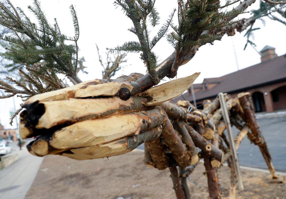 A lever and pulleys allows passersby to make Casey Early-Krueger's interactive sculpture move. It took more than 80 Christmas tree trunks and two weeks for him to create the piece.