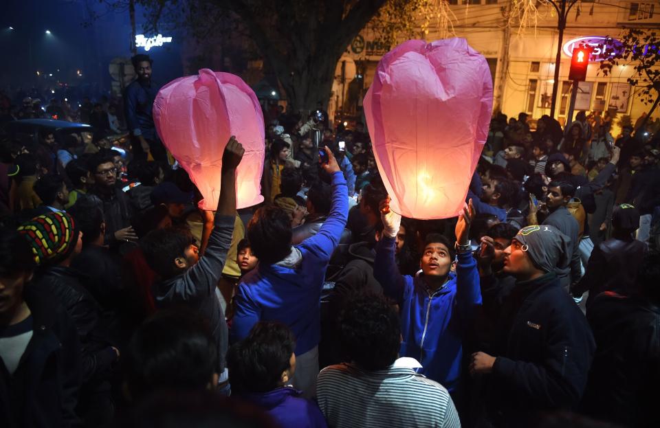 Pakistani people prepare to release lanterns as they gather to celebrate the new year in Lahore on January 1, 2018. (Photo: ARIF ALI via Getty Images)