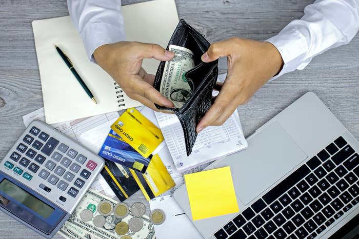 A man looking through his wallet which has little money