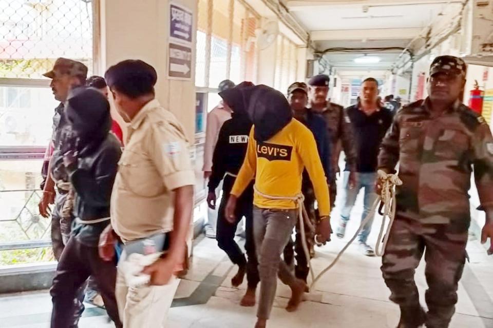 Το αστυνομικό προσωπικό συνοδεύει άνδρες που κατηγορούνται για φερόμενη βάναυση επίθεση σε Ισπανίδα σε περιφερειακό δικαστήριο στην Ντούμκα, στην πολιτεία Τζαρκάντ της Ινδίας (AFP μέσω Getty Images)
