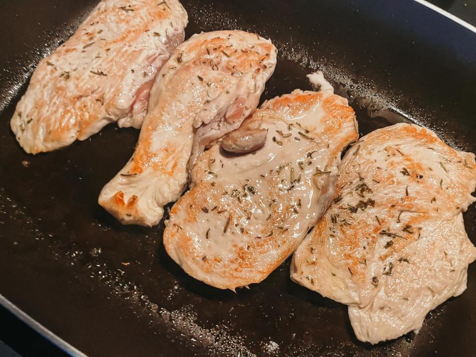 cooked chicken pieces in a skillet pan