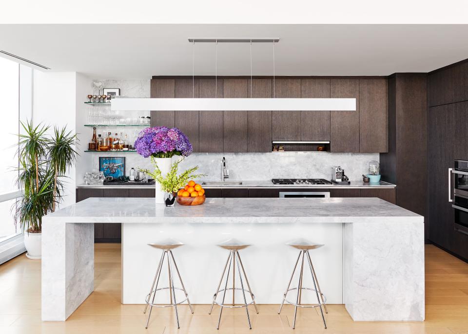 A TV-watching nook in the kitchen’s original design was converted into a wet bar, complete with vintage Baccarat crystal stemware and vintage Gucci sterling-silver rope bar goblets. “Who even sits and looks at a TV? You're looking at your phone, you have an iPad, whatever,” says Deutsch. “We wanted to use that space as something so much more creative and beautiful to look at.” The barstools are by Pepe Cortes for Knoll. Flowers throughout their apartment were arranged by the couple’s longtime fave florist, Michael George.