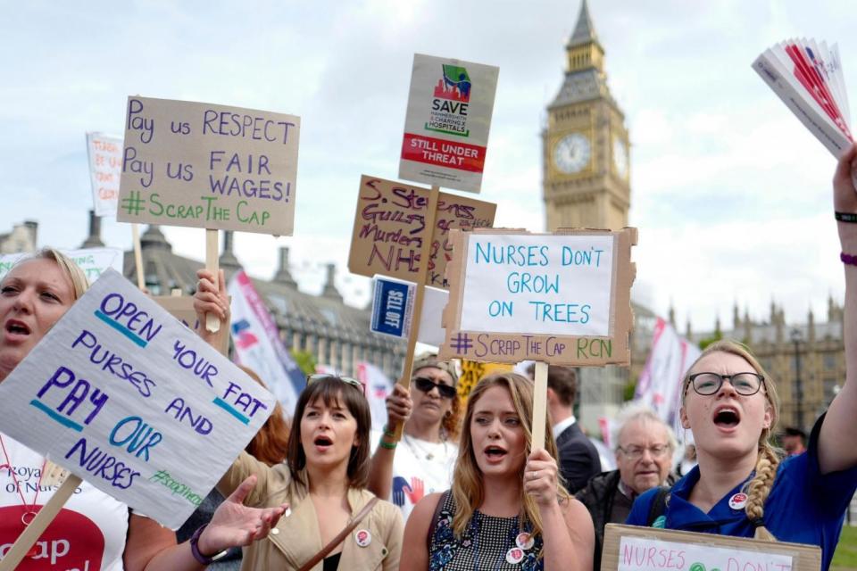 Protesters hold placards against the pay cap on public sector workers outside Parliament in September 2017. The cap was later lifted. (AFP/Getty Images)