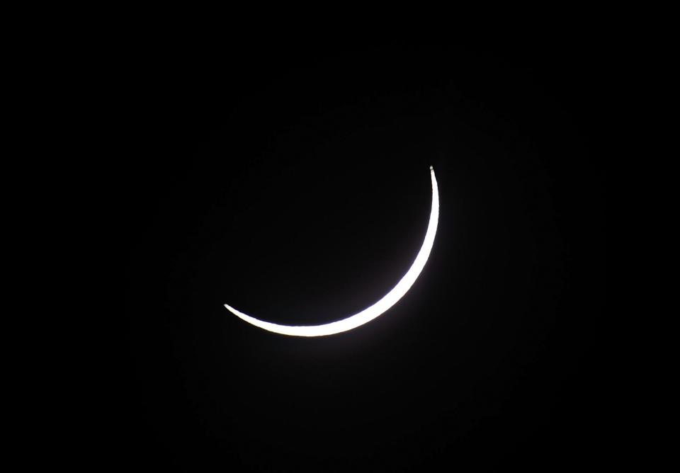 Les spectateurs ont suivi, filmé et photographié le passage de la Lune devant le Soleil, réduit à un disque noir auréolé d'or.<br> (Photo: Ian Hitchcock/Getty Images)