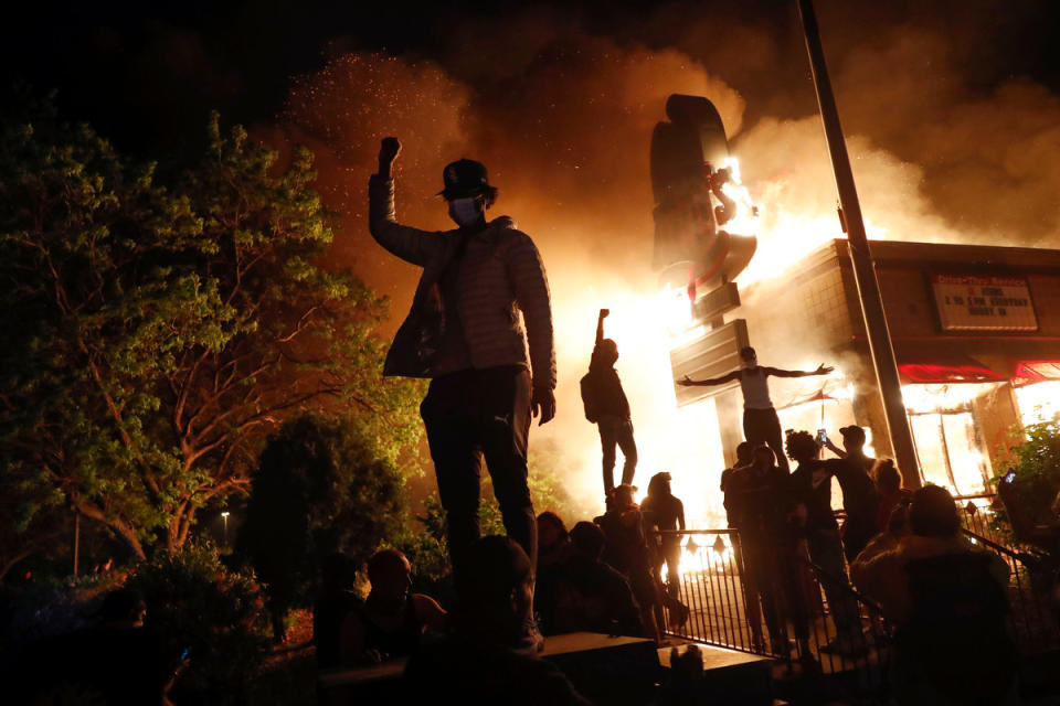 People demonstrate outside a burning Arby's fast food restaurant on May 29, 2020, in Minneapolis during a protest over the death of George Floyd. 