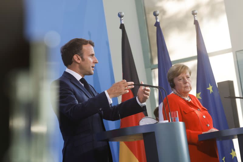 German Chancellor Angela Merkel and French President Emmanuel Macron give a news statement in Berlin