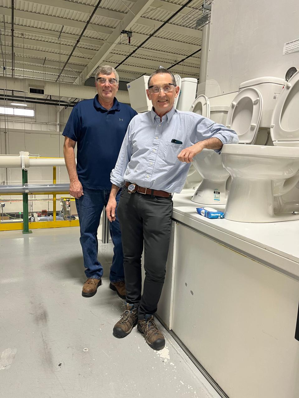 Pete Lortscher, left, and David Powling, right, near toilets used in tests at Kimberly-Clark's Flushability Lab in Neenah, Wisc., on Jan. 25.