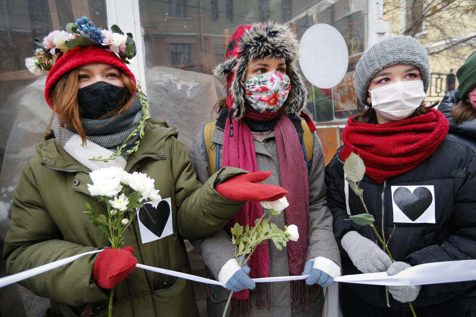 Women, wearing face masks to protect against coronavirus, attend a rally in support of jailed opposition leader Alexei Navalny and his wife Yulia Navalnaya, in Moscow, Russia, Sunday, Feb. 14, 2021. (AP Photo/Alexander Zemlianichenko)