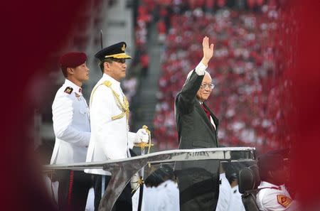 Singapore's President Tony Tan waves to the spectators as he arrives for Singapore's Golden Jubilee celebration parade at Padang near the central business district August 9, 2015. REUTERS/Kevin Lam