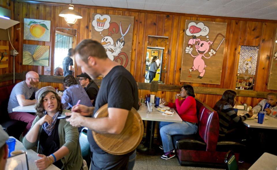 Artwork of pigs and chicken decorate the dining room walls of the Home grown restaurant, Tuesday, Oct. 22, 2013, in Atlanta. A couple miles east of downtown Atlanta on the fringe of a historic blue-collar neighborhood, Home grown serves up satisfying Southern fare in an eclectic atmosphere. (AP Photo/David Goldman)