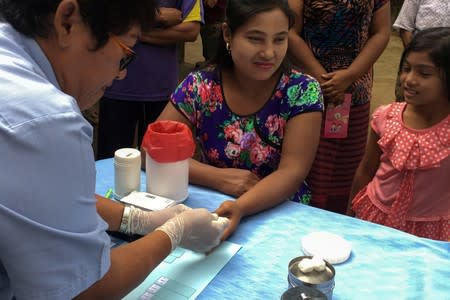 FILE PHOTO: A public health worker takes a blood sample from a woman to be tested for malaria in Bo Rai district, Trat provice