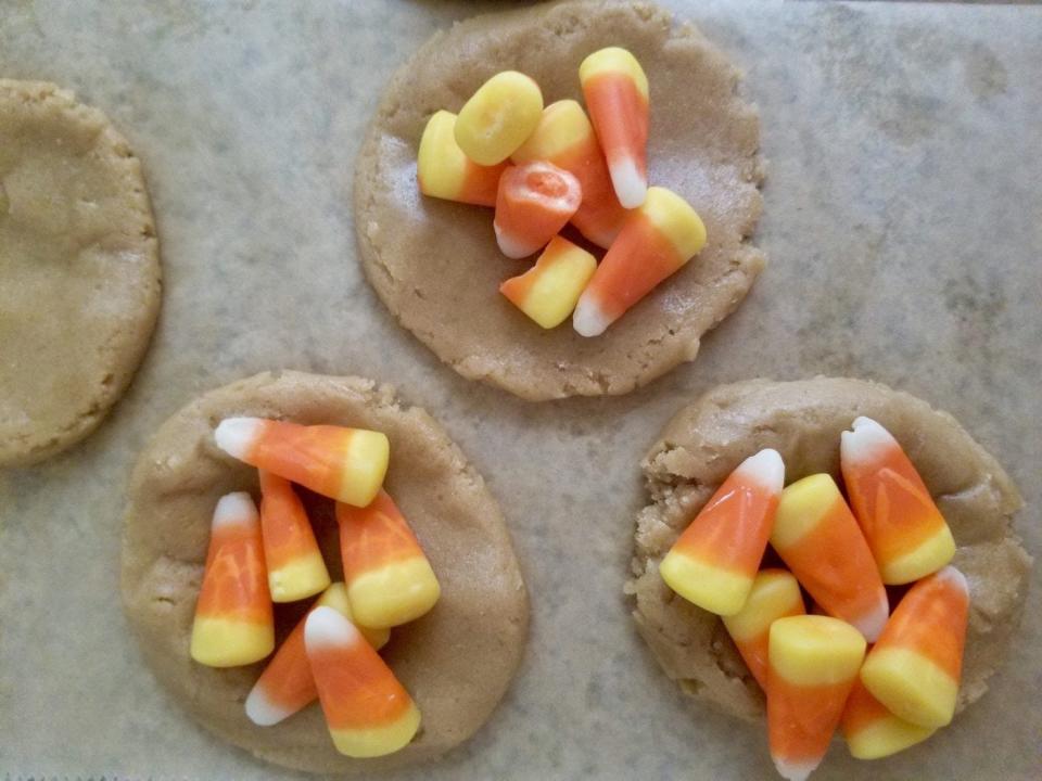 Adding candy corn to cookie dough centers.