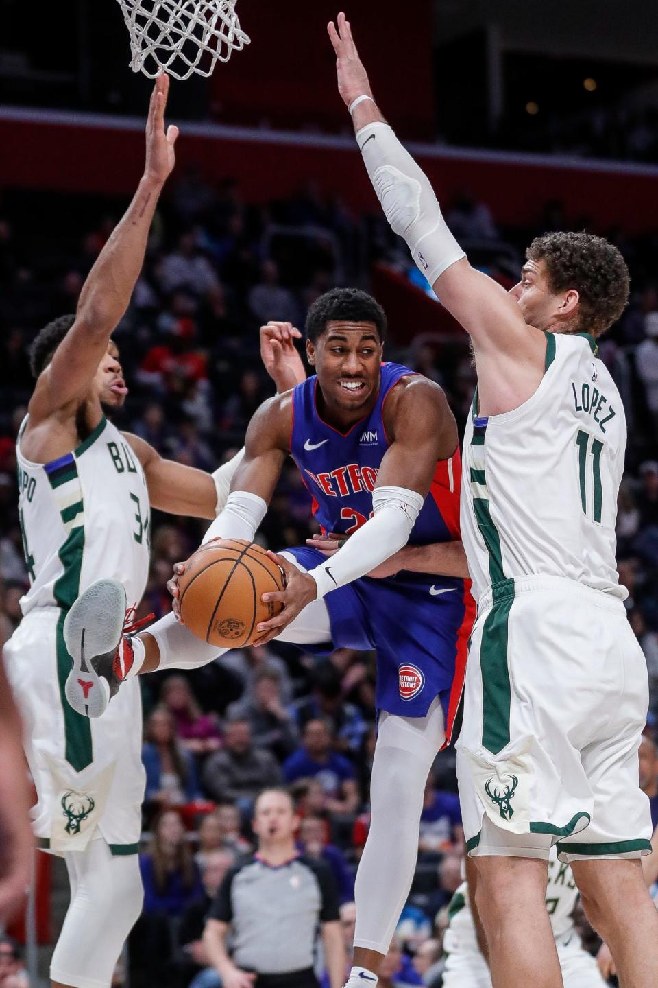 Detroit Pistons guard Jaden Ivey makes a pass against Milwaukee Bucks forward Giannis Antetokounmpo and center Brook Lopez during the second half at Little Caesars Arena in Detroit on Saturday, Jan. 20, 2024.